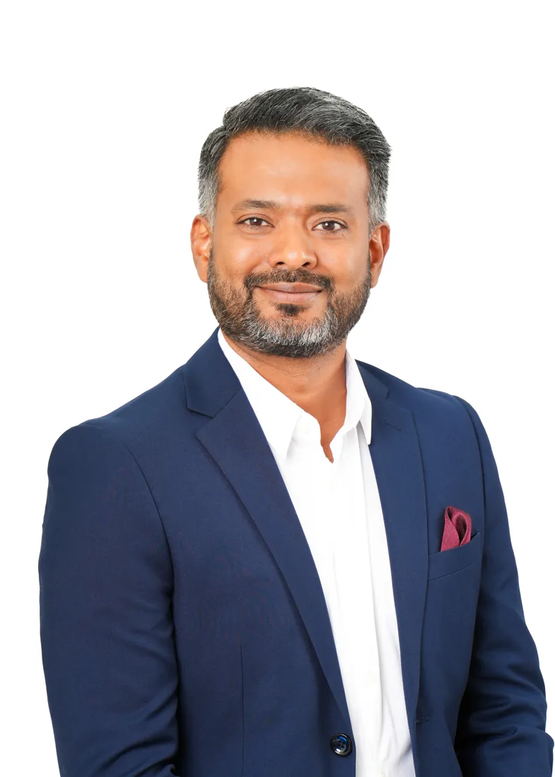 Ash Khan in a navy blazer, smiling